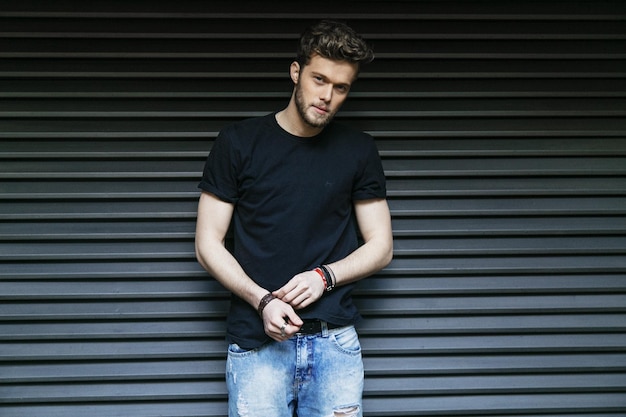 Photo portrait of handsome man standing against shutter