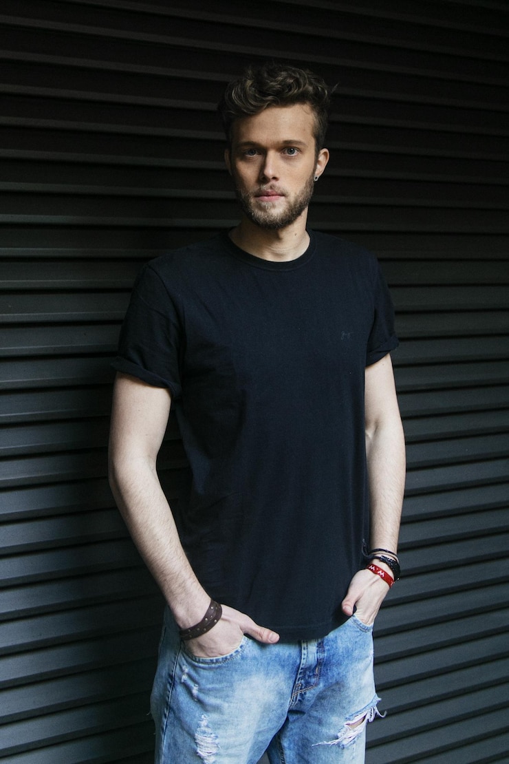 Photo portrait of handsome man standing against shutter