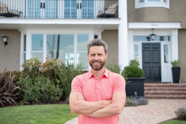 Portrait of handsome man standing outside new home.