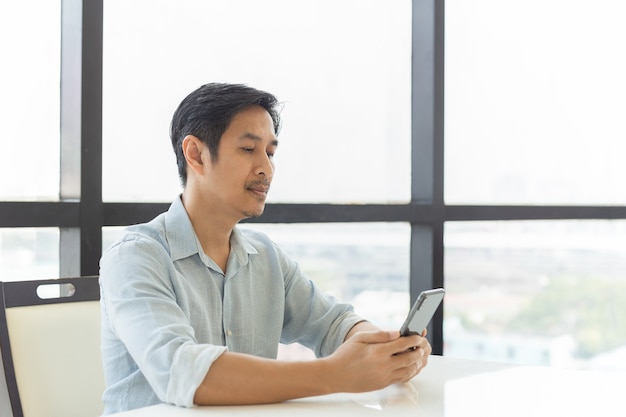 Portrait of handsome man using smart phone in the office