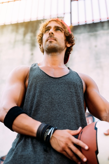 Foto ritratto di uomo bello con abbigliamento sportivo casual e basket.