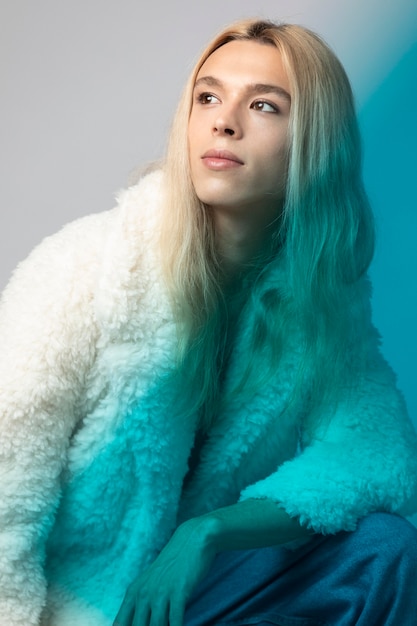 Portrait of handsome man with long blonde hair and fluffy jacket