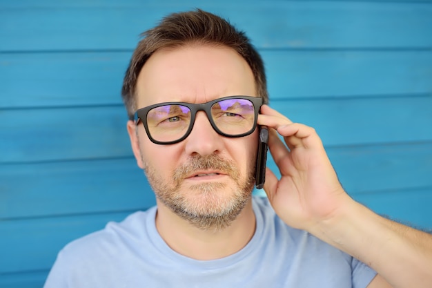 Portrait of handsome mature man talking on the phone. 