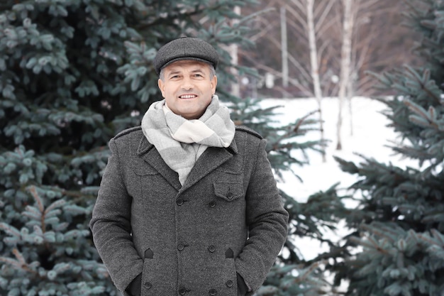 Portrait of handsome mature man in winter park