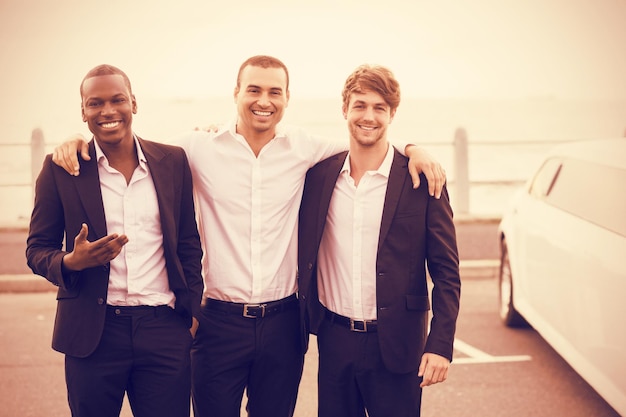 Photo portrait of handsome men posing next to limousine on night out