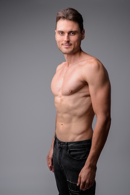 portrait of handsome muscular shirtless man on gray