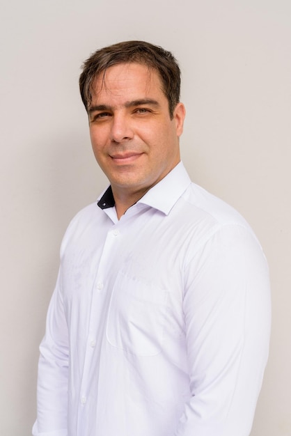 Portrait of handsome Persian man against plain background