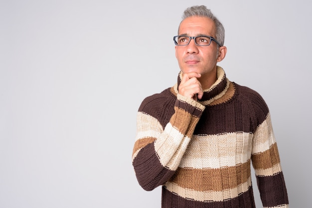 Portrait of handsome Persian man thinking with eyeglasses ready for winter