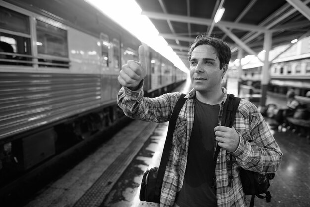 Portrait of handsome Persian tourist man spending holiday and exploring the city of Bangkok in black and white