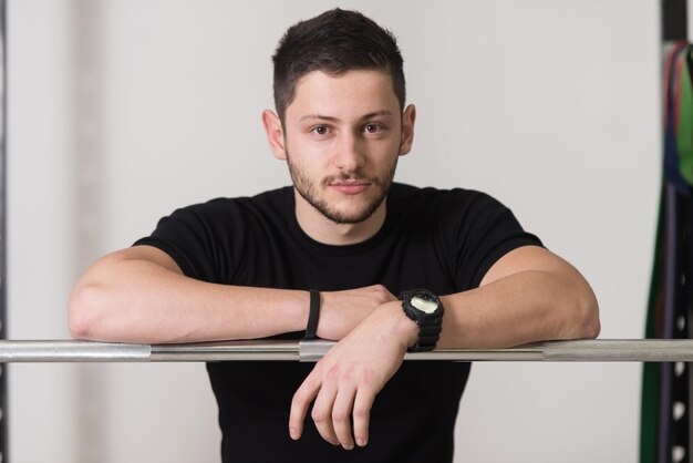 Portrait Of Handsome Personal Trainer Wearing Sportswear In Fitness Center Gym Standing Strong