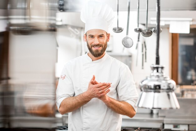 Portrait of handsome positive chef cook at the restaurant kitchen