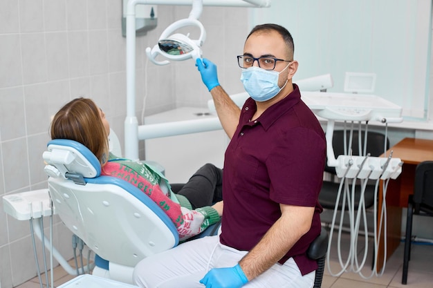 Портрет красивого профессионального стоматолога в его кабинете