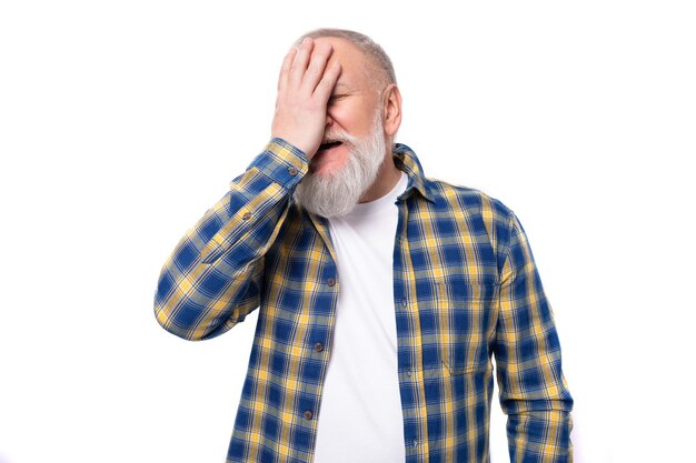 Portrait of a handsome s middleaged grayhaired man with a beard in a shirt covering his face with