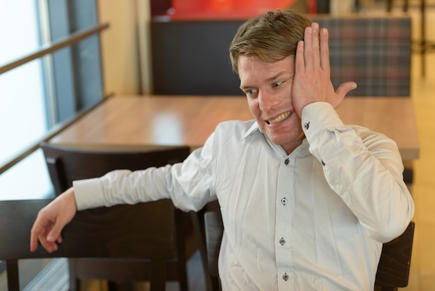 Portrait of handsome Scandinavian businessman with blond hair indoors