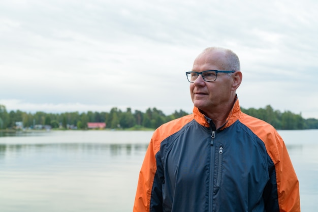 Portrait of handsome senior man on peaceful view of the lake