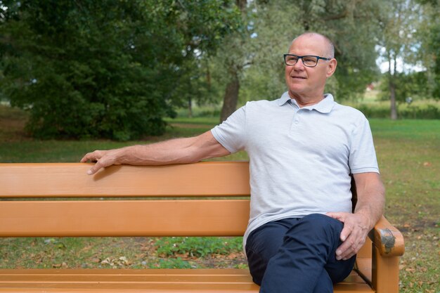 Portrait of handsome senior man relaxing at the park