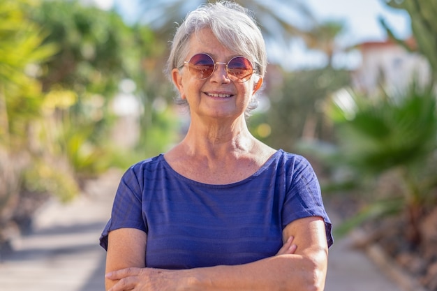 Portrait of handsome senior woman in outdoor, looking at camera smiling