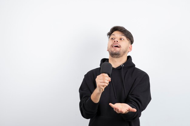 Portrait of handsome singer singing hit in microphone 