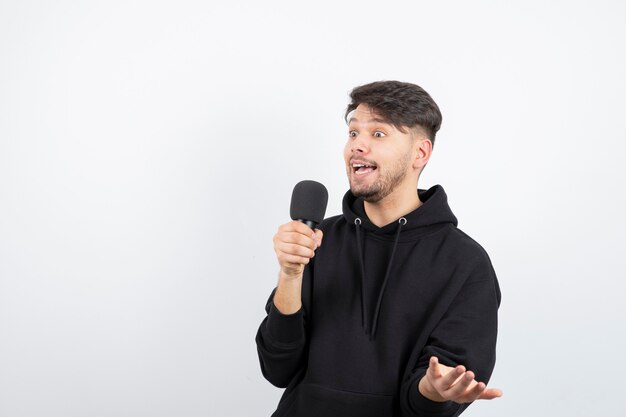 Portrait of handsome singer singing hit in microphone 