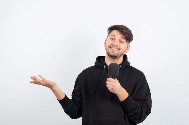 Portrait of handsome singer singing hit in microphone 