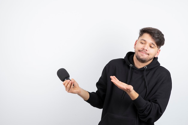 Portrait of handsome singer singing hit in microphone 