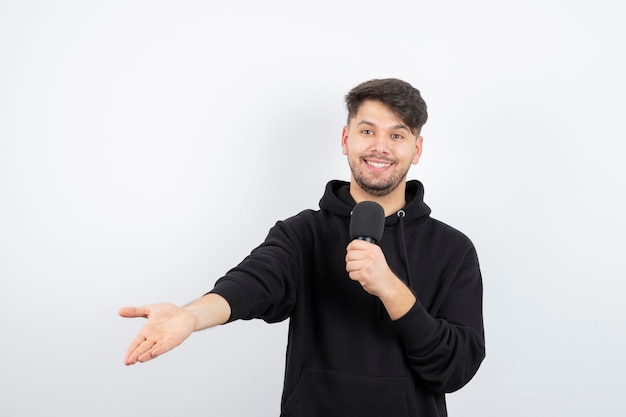 Portrait of handsome singer singing hit in microphone 