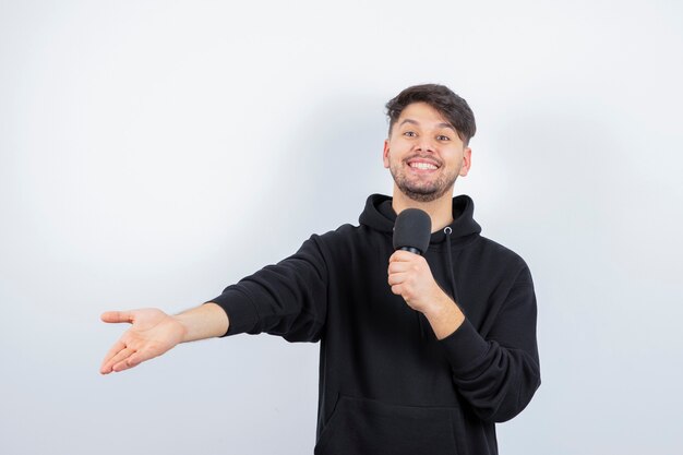 Portrait of handsome singer singing hit in microphone 