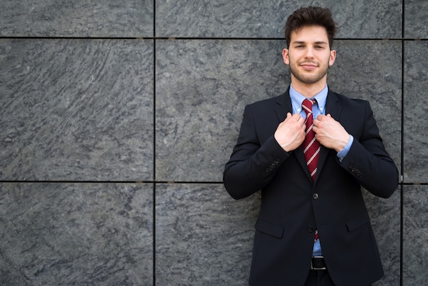 Портрет красивый улыбающийся бизнесмен, корректируя его пиджак