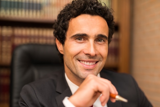 Portrait of an handsome smiling businessman in his office