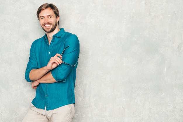 Ritratto del modello di uomo d'affari lumbersexual hipster sorridente bello che indossa i vestiti casuali della camicia dei jeans.