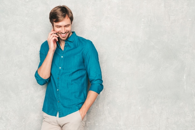 Ritratto del modello di uomo d'affari lumbersexual hipster sorridente bello che indossa i vestiti casuali della camicia dei jeans.