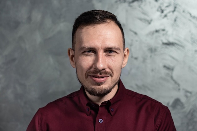 Foto ritratto di un uomo sorridente bello in una camicia marrone rossiccio