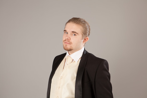 Portrait of handsome smiling young man in a tuxedo