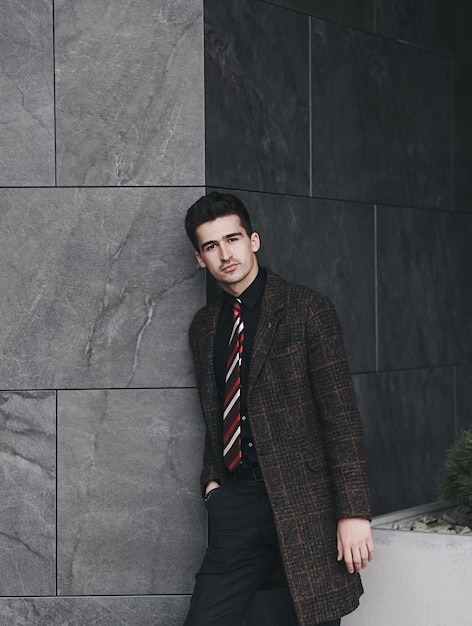 Portrait of handsome stylish man in elegant suit in city