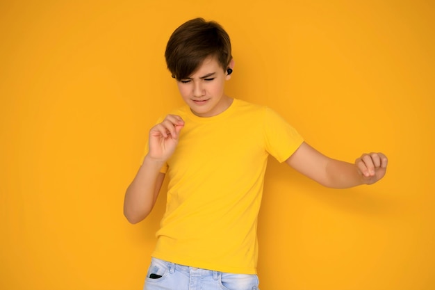 Portrait of a handsome teenager 12-13 years old on a yellow background.