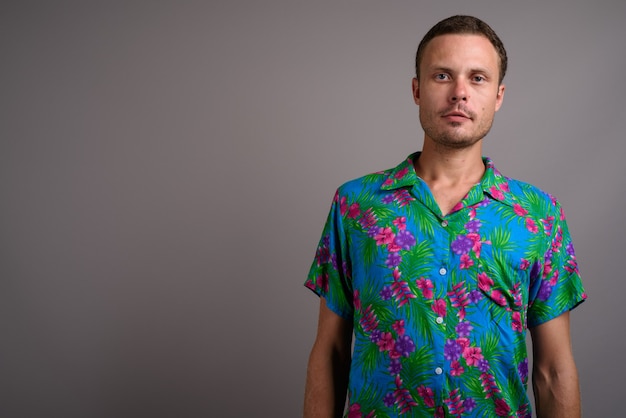 Portrait of handsome tourist man ready for vacation on gray