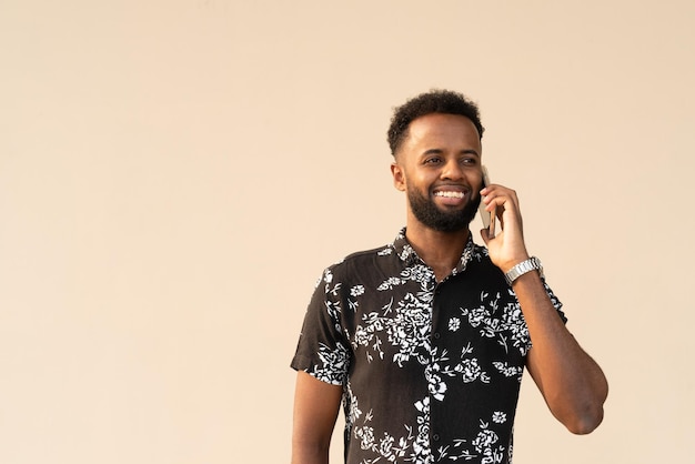 휴대 전화를 사용하여 야외에서 잘 생긴 젊은 아프리카 남자의 초상화
