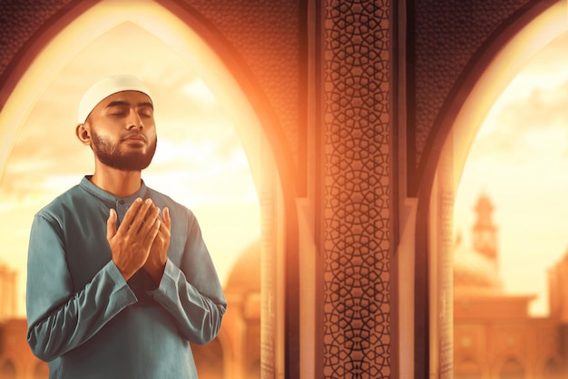 Portrait of handsome young asian muslim man with beard praise thankful