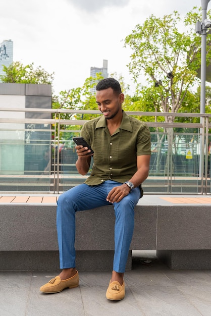 Portrait of handsome young black man outdoors in city