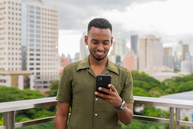 Portrait of handsome young black man outdoors in city