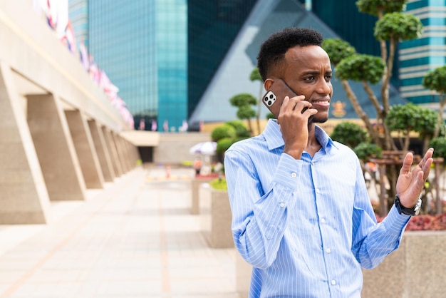 Portrait of handsome young black man outdoors in city