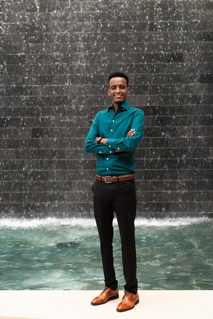 Portrait of handsome young black man outdoors in city