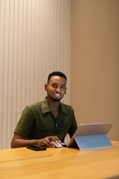 커피숍에서 노트북 컴퓨터를 사용하는 잘생긴 젊은 흑인 남성의 초상화