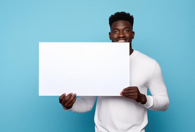 Portrait of handsome young black man in a white tshirt holding an empty board on a blue background