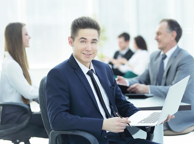 Portrait of handsome young business man and laptop