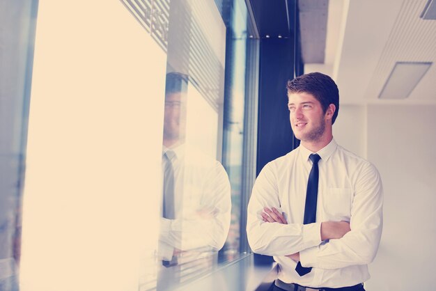 Portrait of a handsome young business man on a meeting in offce with colleagues in background