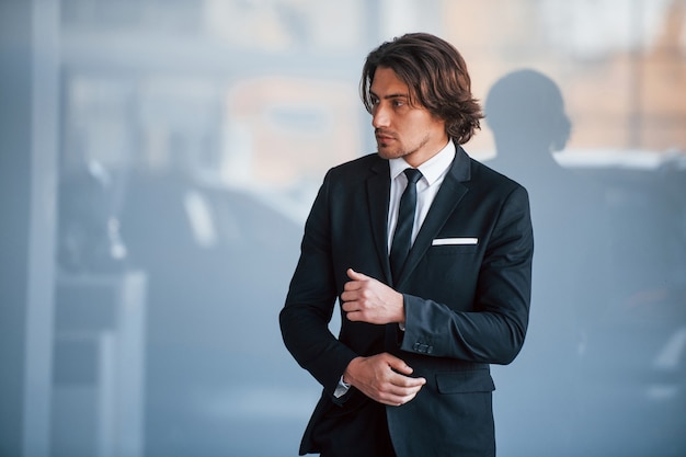 Portrait of handsome young businessman in black suit and tie.