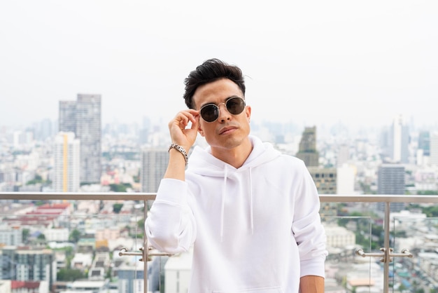 Portrait of handsome young cool man in city wearing sunglasses