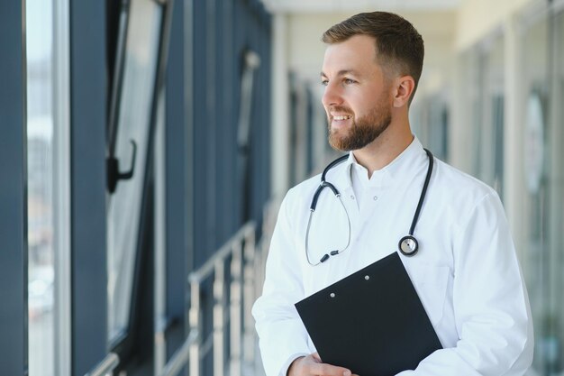 Portrait of handsome young doctor on hospital corridor