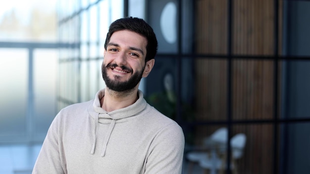 Portrait of handsome young male entrepreneur posing in office co